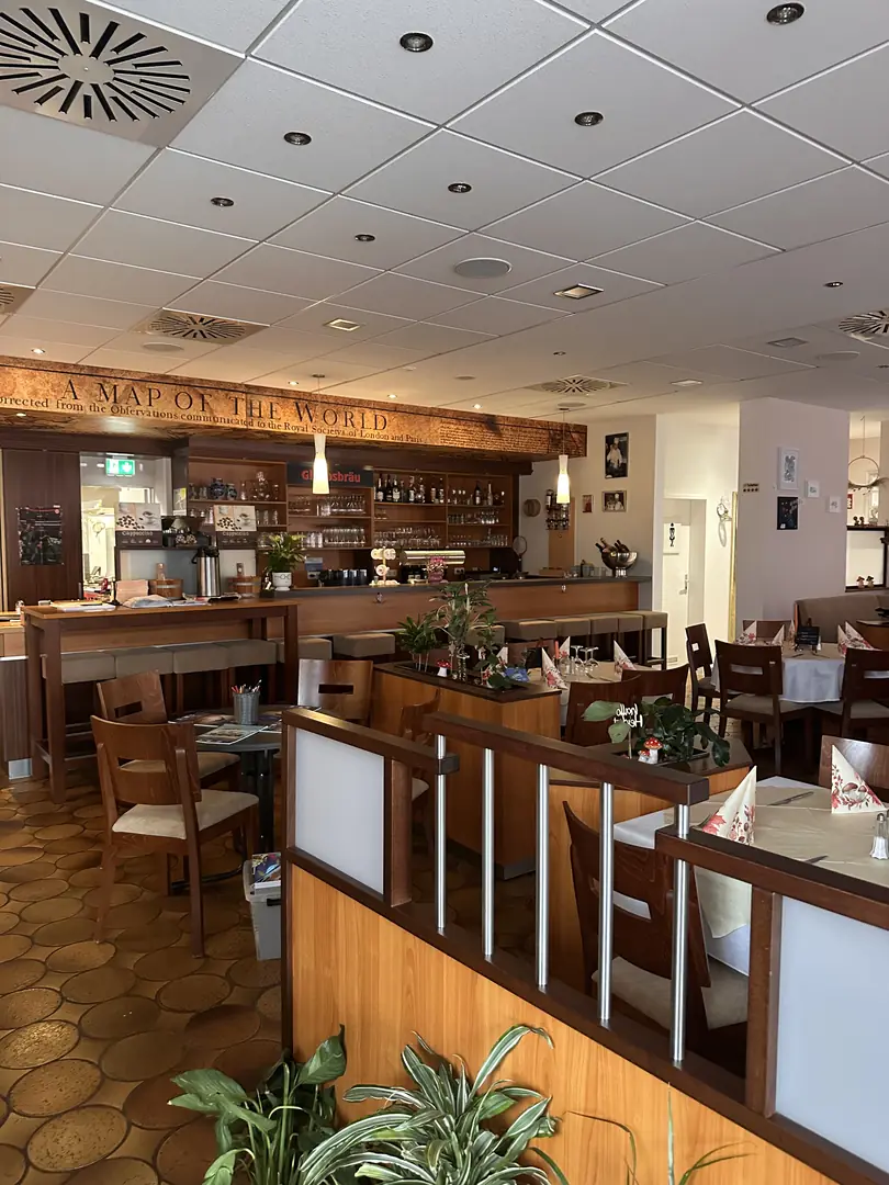 Gastraum des Restaurant Bürgerhaus Zellhausen mit eingedeckten Tischen und Blick auf die Theke